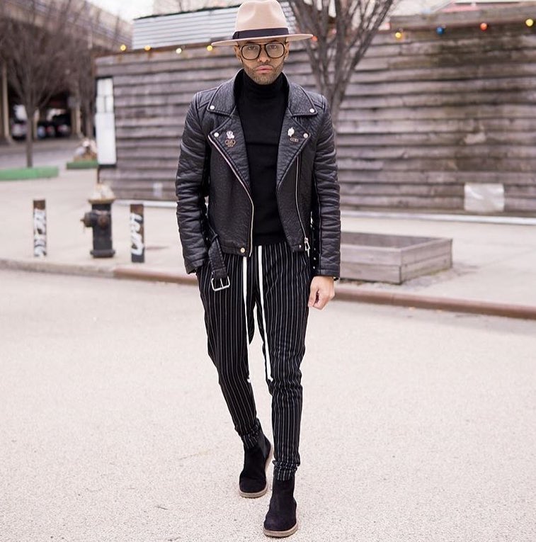 Leather biker jacket, sweater, dress pants, boots, hat