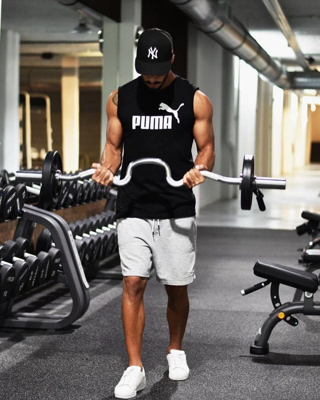Sleeveless muscle tee, short sport pants, snapback cap and sport shoes