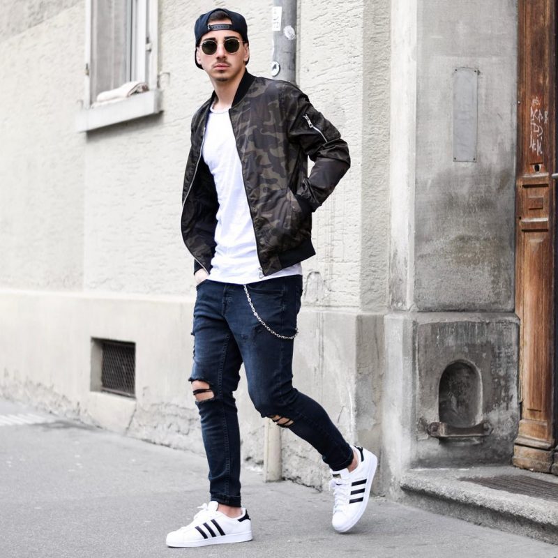 Snapback cap, camo bomber jacket, blue jeans, white sneaker 1