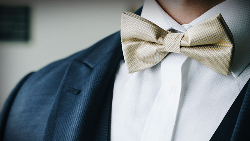 groom wearing textured beige bow tie